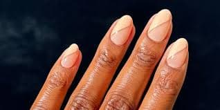 Uñas en almendra con una delicada francesa nude durazno sobre piel cálida
