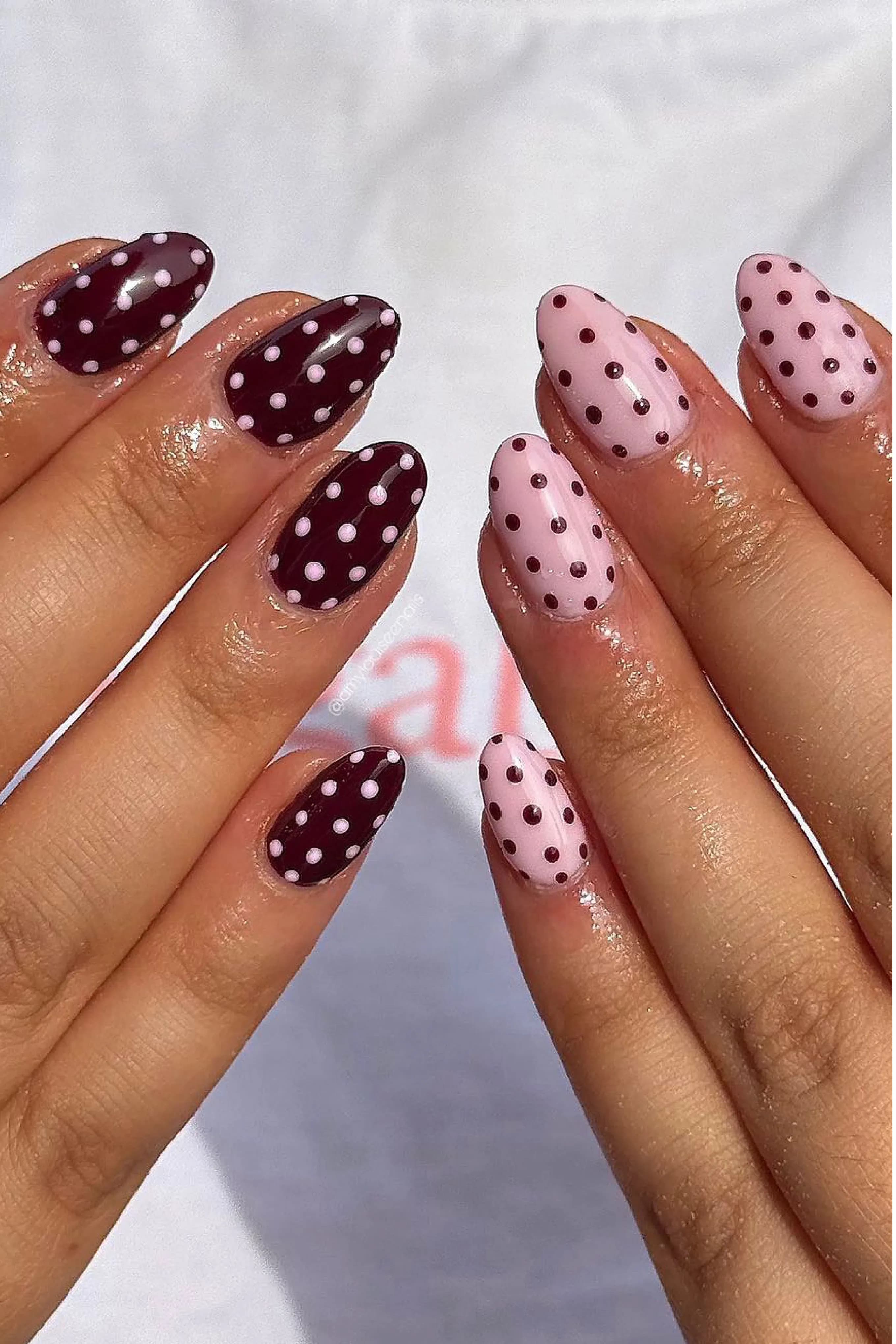 Uñas en almendra con lunares, alternando burdeos con puntos blancos y rosa pálido con puntos oscuros